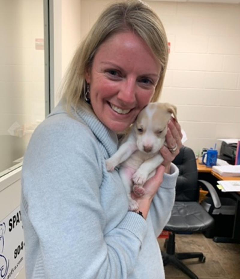 Accountant holding a puppy at Gloucester Mathews Humane Society